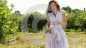 Beautiful young woman long hair bright makeup nature background landscape dry spike grass and apple trees garden summer model