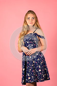 Beautiful young woman with long hair in dress on pink background