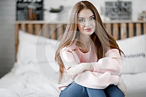 Beautiful young woman with long hair posing for the camera at home.