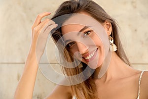 Beautiful young woman with long hair. Positive emotional portrait of a pretty smiling girl.