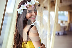 Beautiful young woman with long hair in a summer day. bridesmaid in yellow dress in a sea restaurant