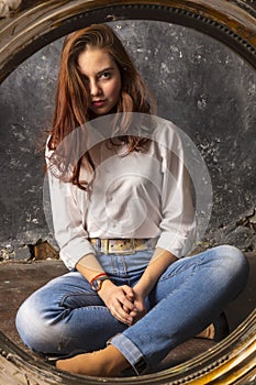 Beautiful young woman looking on her reflection at the mirror