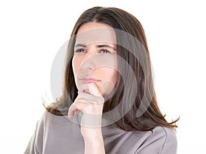 Beautiful young woman looking side pensive dreaming while posing against white background wall