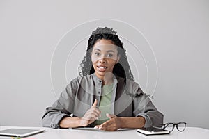 Beautiful young woman looking and speaking through the web camera while making a video conference from office or home