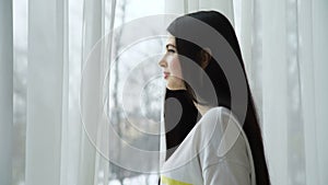 Beautiful young woman looking window waiting