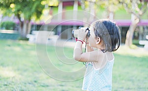 Beautiful young woman looks through binoculars at the national park on a sunny day