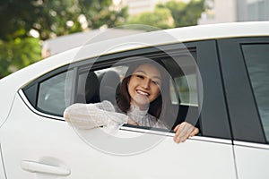 Beautiful young woman, looks out the window a white car
