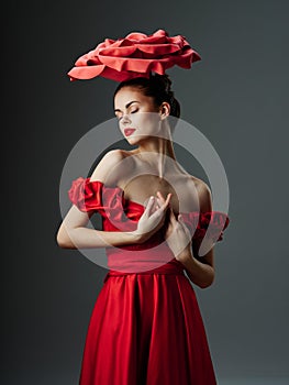 Beautiful young woman in a luxurious dress with roses, rose petals