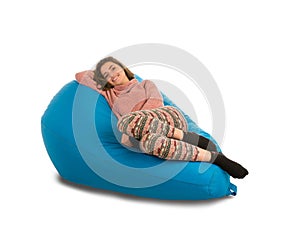 Beautiful young woman lying on blue beanbag sofa