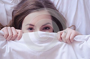 Beautiful young woman lying down in bed