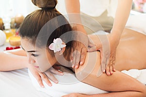 Beautiful young woman lying down on the bed relax in spa salon with massage