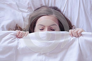 Beautiful young woman lying down in bed and sleeping