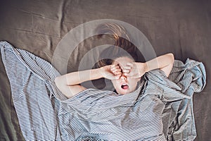 Beautiful young woman lying down in bed and sleeping, top view. Do not get enough sleep concept