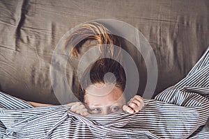 Beautiful young woman lying down in bed and sleeping, top view. Do not get enough sleep concept