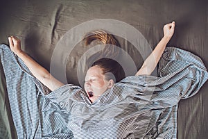 Beautiful young woman lying down in bed and sleeping, top view. Do not get enough sleep concept