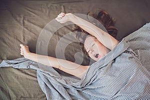 Beautiful young woman lying down in bed and sleeping, top view. Do not get enough sleep concept