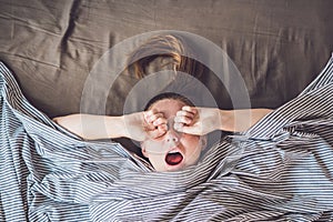 Beautiful young woman lying down in bed and sleeping, top view. Do not get enough sleep concept