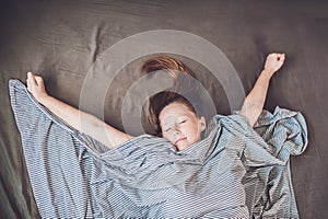 Beautiful young woman lying down in bed and sleeping, top view. Do not get enough sleep concept