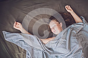 Beautiful young woman lying down in bed and sleeping, top view. Do not get enough sleep concept