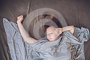 Beautiful young woman lying down in bed and sleeping, top view. Do not get enough sleep concept