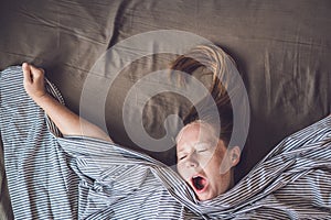 Beautiful young woman lying down in bed and sleeping, top view. Do not get enough sleep concept