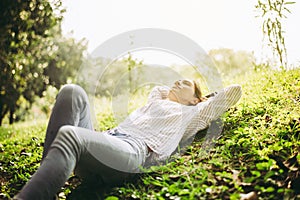 Beautiful young woman lying down with hands on head and sleeping at public park,Relaxing time,Happy and smiling,Positive thinking