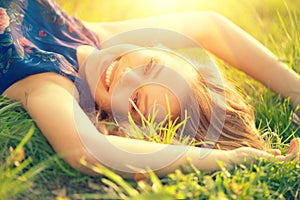 Beautiful young woman lying on the field