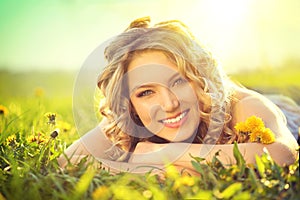 Beautiful young woman lying on a field