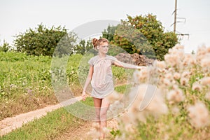 Beautiful Young Woman lying on the field in green grass and blowing dandelion. Outdoors. Enjoy Nature. Healthy Smiling Girl on spr