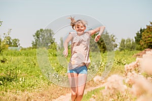 Beautiful Young Woman lying on the field in green grass and blowing dandelion. Outdoors. Enjoy Nature. Healthy Smiling Girl on spr