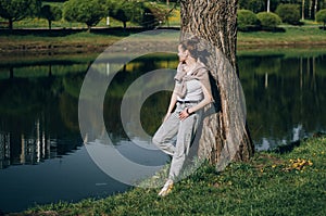 Beautiful Young Woman lying on a field, green grass and dandelion flowers. Outdoors Enjoy Nature. Healthy Smiling Girl lying in photo