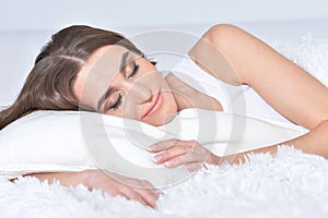 Beautiful young woman lying on soft bed