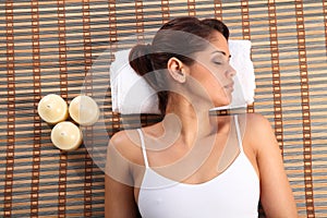 Beautiful young woman lying in spa head on towel