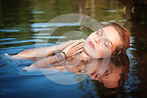 Beautiful young woman lying in the water