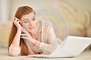 Beautiful young woman lying on wooden floor