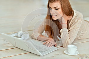 Beautiful young woman lying on wooden floor