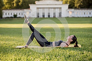 Beautiful young woman lying on a yellow mattress doing pilates or yoga, the hundred intermediate exercises