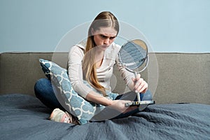 Beautiful young woman with make-up mirror sitting at home in bed