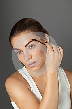 Beautiful Young Woman With Makeup Brush Applying Black Mascara On Eyelashes. Skin Care.