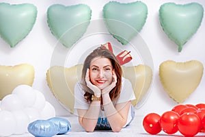 Beautiful young woman on many colorful heart balloons background. smiles,funny Valentine s Day birthday party