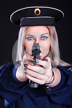 Beautiful young woman in a marine uniform with a gun (focus is o