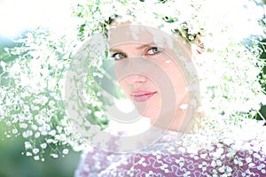 Beautiful young woman on the meadow with white flowers on a warm