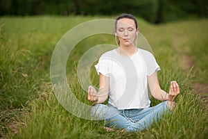 Beautiful young woman meditate on meadou na early summer evening