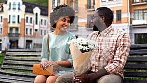 Beautiful young woman meeting boyfriend on first date, man presenting flowers