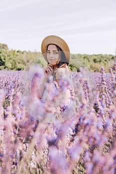 Beautiful young woman in the middle of a blooming lavender field