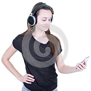 Beautiful young woman model face on cell phone looking up while listening to music in headphones standing against white background