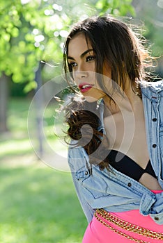 Beautiful young woman, model of fashion, in a garden