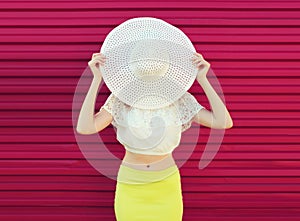 Beautiful young woman model posing in white summer straw hat