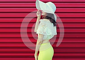 Beautiful young woman model posing in white summer straw hat