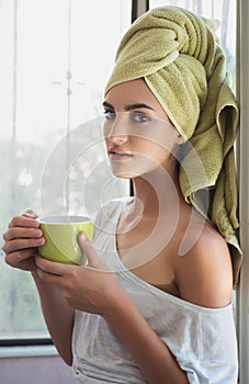 Beautiful young woman with morning cup of hot beverage.